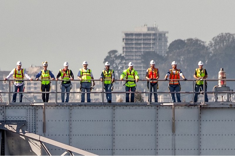workers in safety gear on a bridge